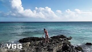 A fit girl is playing with her body on a nude beach, showcasing her erotic charm