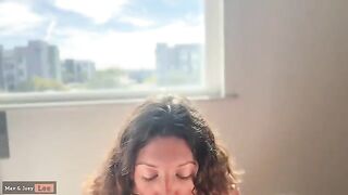 A cute woman has sex in front of the open window, showcasing her skills