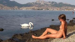 A girl went swimming naked in the river and sunbathed on the bank