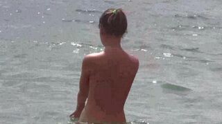 A group of naked people are having fun on the beach