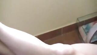 A naked girl with big natural tits is smoking in the kitchen