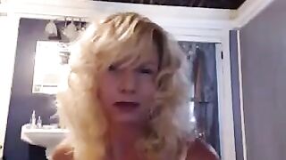 A mature woman plays with herself in the bathroom, using a vibrator to achieve orgasm