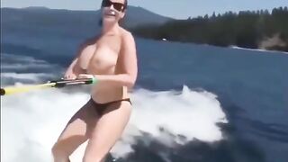 A sexy girl is water skiing without any clothes on