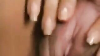 A girl with a big clit plays with her hairy pussy