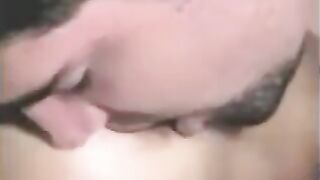 A man has sex with a girl with a strapon and another girl fingering him