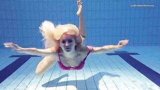 A hot and sexy woman is swimming naked in the pool