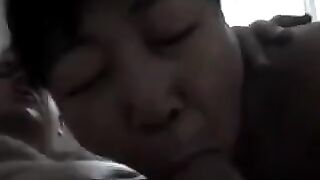 An experienced Chinese woman teaches the guy how to perform a blowjob