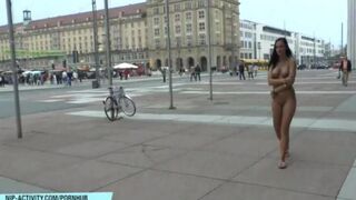 A hot chick is walking naked on the city streets and showing herself