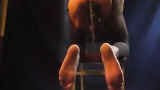 A muscular guy caresses his cock through pantyhose