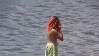 A hot nudist is walking on the bare foot on the coast of Crimea