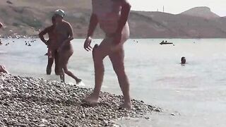 A hot nudist is walking on the bare foot on the coast of Crimea