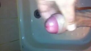 The kid caresses his dick under the shower with his hand