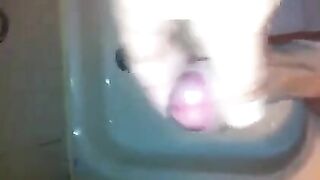 The kid caresses his dick under the shower with his hand