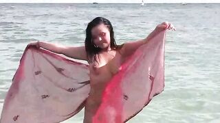A young girl is bathing in the nude in the sea