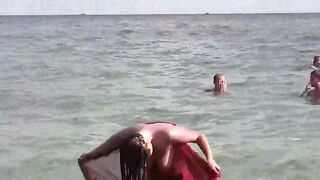 A young girl is bathing in the nude in the sea