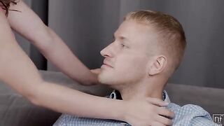 A girl is giving herself to a man on the couch in a sensual act